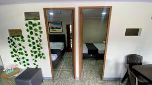 a room with a mirror and a room with two beds at Apartamento central en Armenia in Armenia +2 photos