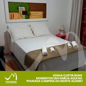 una camera da letto con un grande letto con due pantofole sopra di Pousada Campina do Monte Alegre a Campina do Monte Alegre