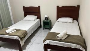 due letti uno accanto all'altro in una stanza di Pousada Campina do Monte Alegre a Campina do Monte Alegre