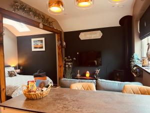 a bedroom with a bed and a table with a basket at TyCosy in St. Davids