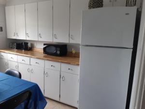 een keuken met witte kasten en een witte koelkast bij Markland Cottage Winery in Whitbourne +5 foto's