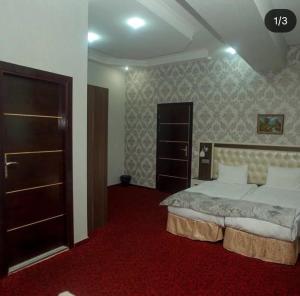 una camera con un grande letto e un tappeto rosso di Ambiance Hotel a Baku