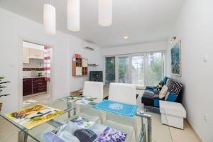 ein Wohnzimmer mit einem Glastisch und Stühlen in der Unterkunft Apartment Villa Sara in Dramalj