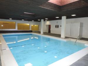 a large swimming pool with blue water in a building at La Riva (240 Ri) in Lenzerheide
