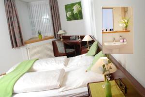 a room with a bed with a sink and a mirror at Altstadt Hotel Meppen in Meppen