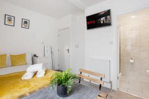 ロンドンにあるStudio in Londonのベッドルーム(ベッド1台、ベンチ、テレビ付)