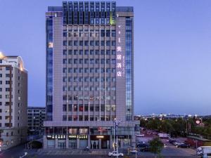 a tall building with a sign on the side of it at Mercure Ordos Downtown in Ordos