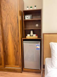 a small refrigerator in a room with a shelf at Sheraton ganna view inn in Alexandria