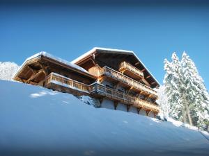 un edificio sobre una colina nevada con nieve en Chalet Les Pellys - OVO Network, en Samoëns