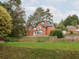 a large red brick house on a grass field at The Croft in Vowchurch