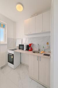 ブカレストにあるSouth Pearl Studioのコンロとシンクのある白いキッチン