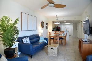 Una sala de estar con un sofá azul y un comedor. en Treasure Island-Free Parking, en St Pete Beach