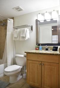 Un baño con inodoro, lavabo y espejo. en Treasure Island-Free Parking, en St Pete Beach