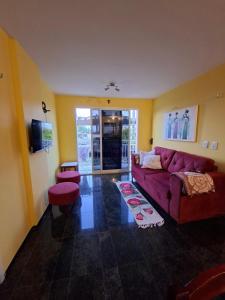 a living room with a purple couch and stool at Apartamento Mobiliado Vila Iracema in Fortaleza