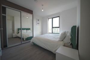 Ένα ή περισσότερα κρεβάτια σε δωμάτιο στο Modern 2BR Wembley Apartment Stadium Views and Balcony
