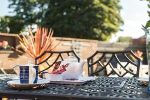 a table with a tea pot and cups on it at 2BR Hotel-Style Near Beach, Free Parking, Sleeps 4 in Edinburgh
