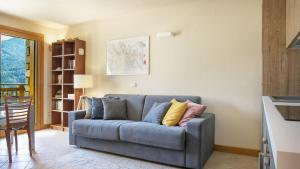 a living room with a blue couch with pillows at Villa Nice View in Ponte di Legno