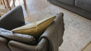 a couch with a pillow and a laptop on it at Villa Nice View in Ponte di Legno