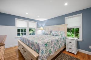 a bedroom with a bed and two windows at 111 Eileen Street Yarmouth Port - Starfish Escape in Yarmouth