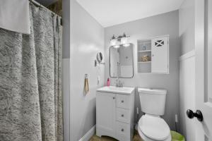 a bathroom with a toilet and a sink and a mirror at 111 Eileen Street Yarmouth Port - Starfish Escape in Yarmouth +32 photos