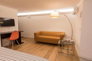 a hotel room with a couch and a desk at Casa Fabrizio Ai Gradoni Di Chiaia in Naples