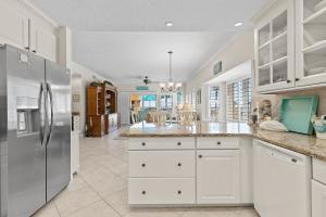 a kitchen with white cabinets and a stainless steel refrigerator at Atlantic Villas 102 in Chicken Island