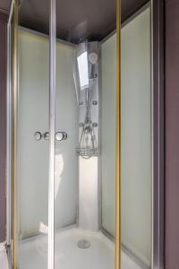 a shower with a glass door and a light at Love Room Alsace Escale du Désir in Niederbronn-les-Bains