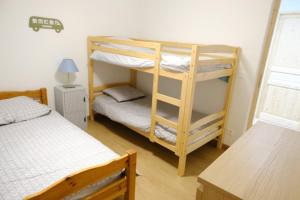 une chambre avec deux lits superposés et un bureau dans l'établissement Loue Appartement Neuf, à Err