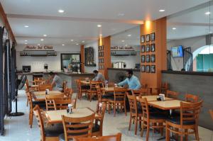 a restaurant with people sitting at tables in a restaurant at Hotel Autlan in Autlán de Navarro