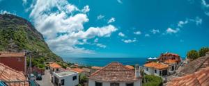 Una vista de un pueblo con el océano al fondo. en Éden Jardim Mar, en Jardim do Mar