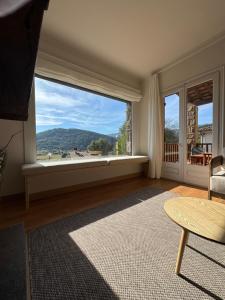 a living room with a large window and a table at el bosc in Sant Jaume de Llierca