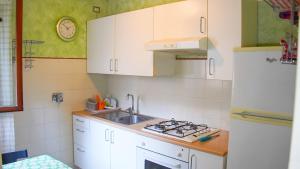 Una cocina con fregadero y refrigerador blanco. en Casa Vacanze della Pineta, en Lido di Ostia