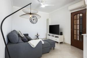 a living room with a couch and a flat screen tv at Golfinho - Sea view with pool by HD in Quarteira