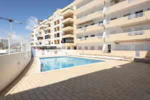 a swimming pool in front of a building at Golfinho - Sea view with pool by HD in Quarteira