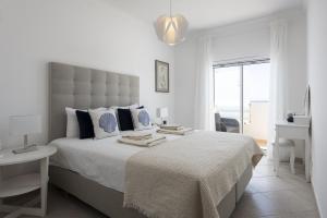 a white bedroom with a large bed and a window at Golfinho - Sea view with pool by HD in Quarteira +21 photos