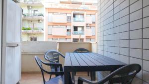 a table and chairs on a balcony with a building at Casa Vacanze della Pineta in Lido di Ostia