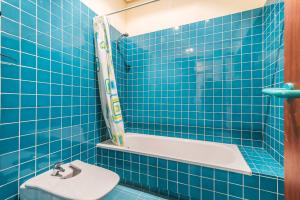 a blue tiled bathroom with a tub and a toilet at Santa Barbara Vegueta in Triana +32 photos