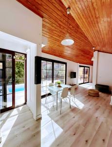 a living room with a wooden ceiling and a table and chairs at Una Casa Canaria Moderna in Ingenio