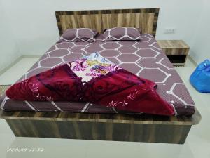 - un lit avec une couverture rouge dans l'établissement Hotel Nitharwal Palace, à Khātu 9 autres photos