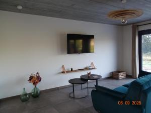 a living room with a blue couch and a table at Au pré de la fauchée in Bièvre