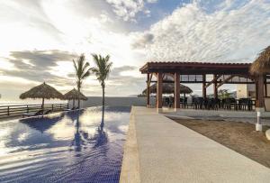einen Pool mit Pavillon am Strand in der Unterkunft El Secreto Residencial in Ixtapa-Zihuatanejo International