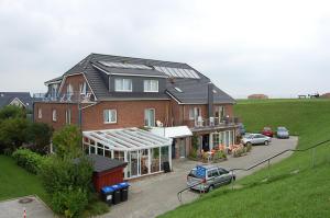 a large house with a car parked in front of it at Ferienhaus Strandlöper Reiners in Horumersiel