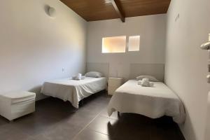 zwei Betten in einem Zimmer mit weißen Wänden in der Unterkunft Finca House By Fataga Maspalomas in Artedara + 36 Fotos