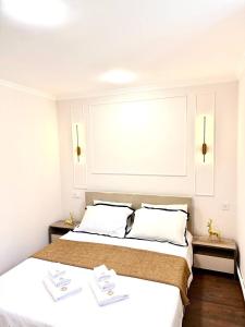 久姆里Aramenc的卧室设有两张床,拥有白色的墙壁和木地板