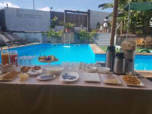 a table with food on it next to a swimming pool at Quinta Refúgio in Ribeirão Chiqueiro