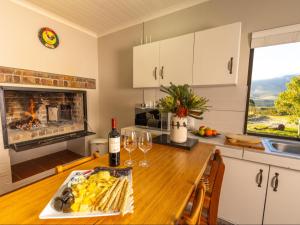 a kitchen with a table with wine glasses and a fireplace at Die Tuin in Stanford