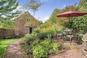 a garden with a table and an umbrella at 2 Bed in The Hendre oc-h33314 in New Castle