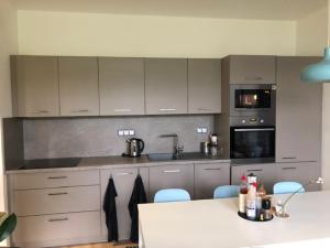 a kitchen with gray cabinets and a white counter top at Ticho a Klid in Zelená Lhota +9 photos