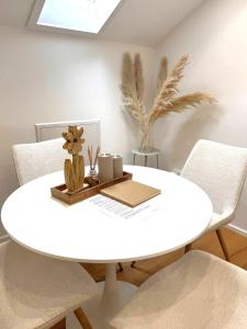 a white dining room table with chairs and a white table at Cozy Alpenloft Chiemsee by Dollop Living in Bernau am Chiemsee