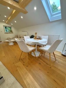 a living room with a white table and chairs at Cozy Alpenloft Chiemsee by Dollop Living in Bernau am Chiemsee